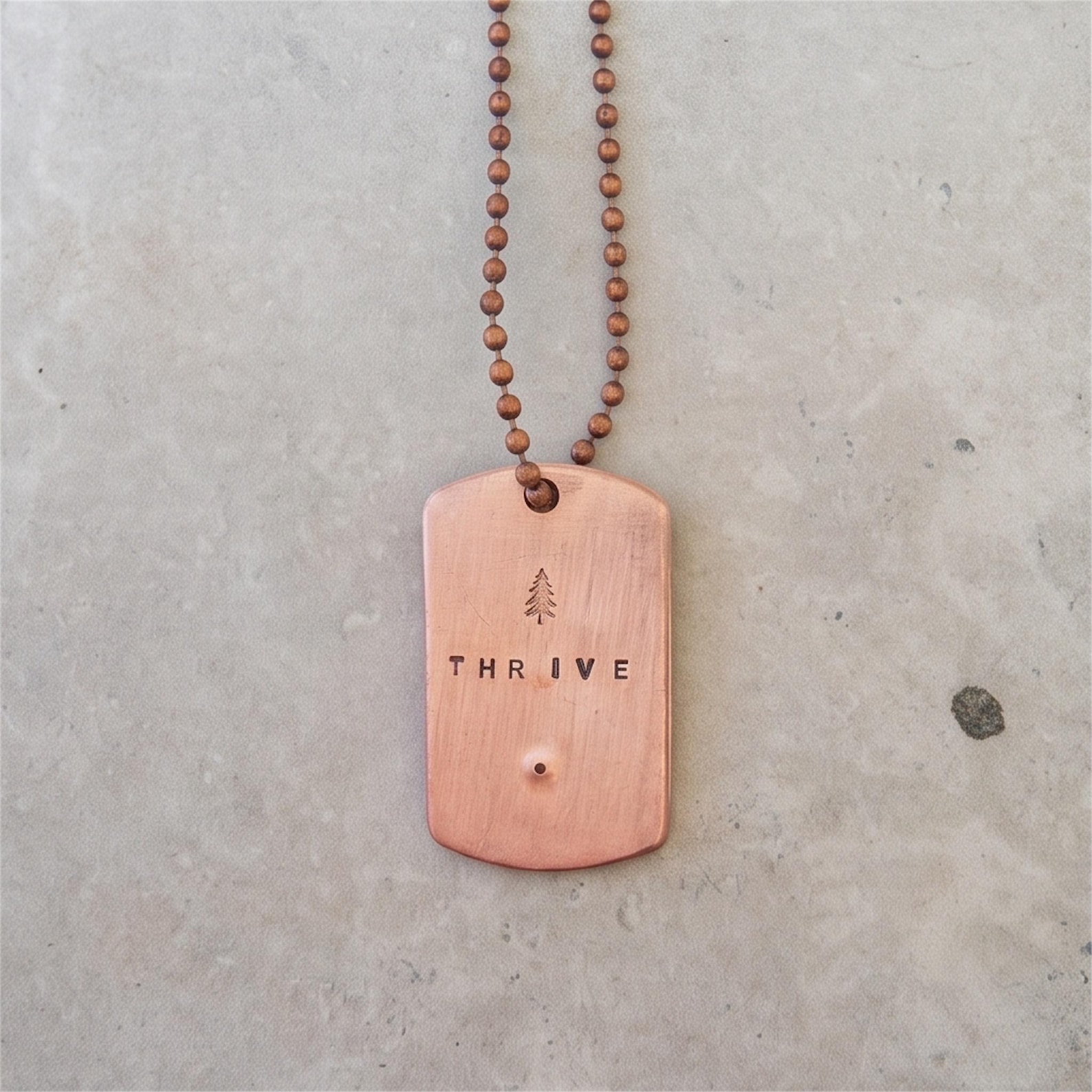 Hand-stamped copper THRIVE dog tag necklace with tree symbol